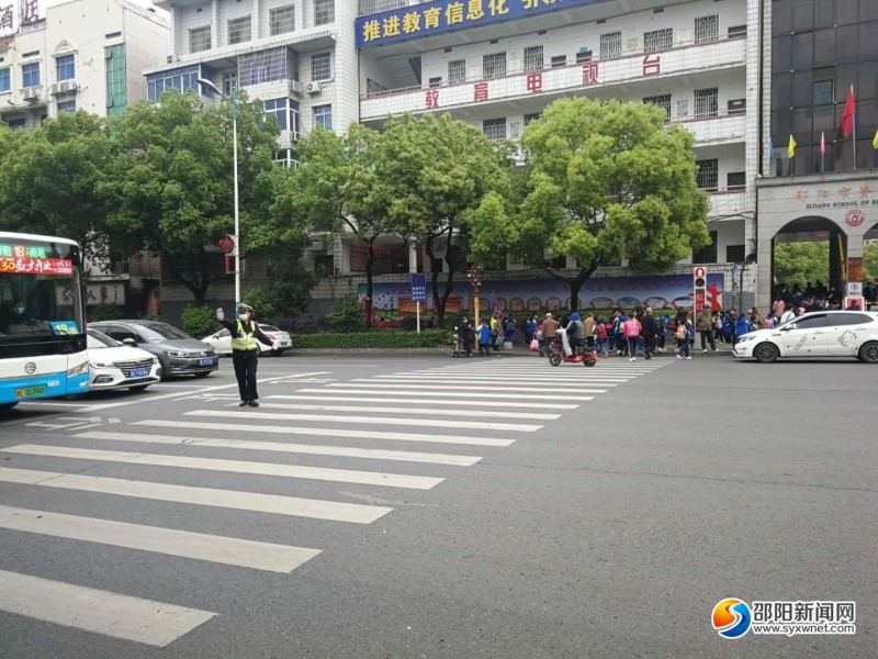 邵阳市区资江学校门口，交警正在指挥交通。  