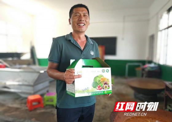 扶贫车间负责人唐方华介绍自己的皮咸蛋产品。