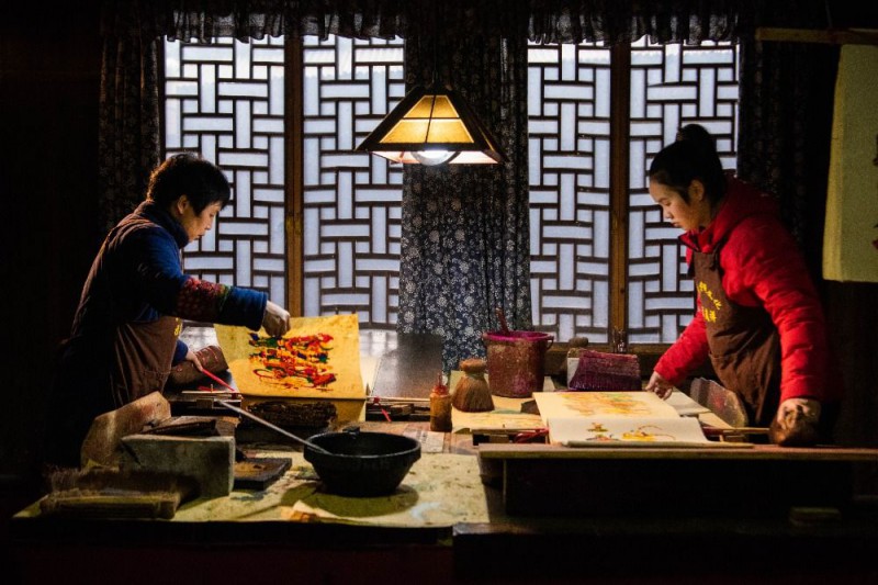 年画艺人尹冬香（左）和女儿肖扬在印制年画